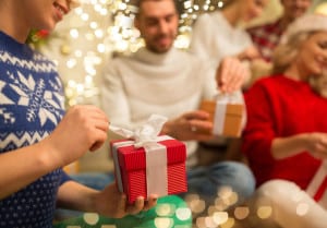 close up of friends opening christmas gifts